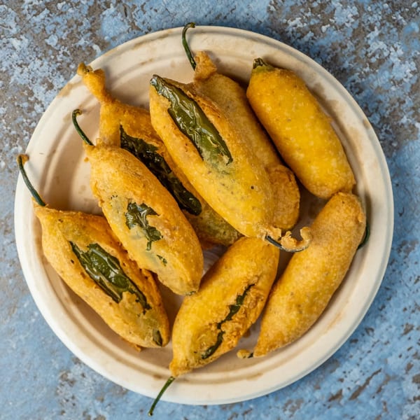 A plate of golden-fried chili peppers, known as Mirchi Bhaji, from Hello! India.