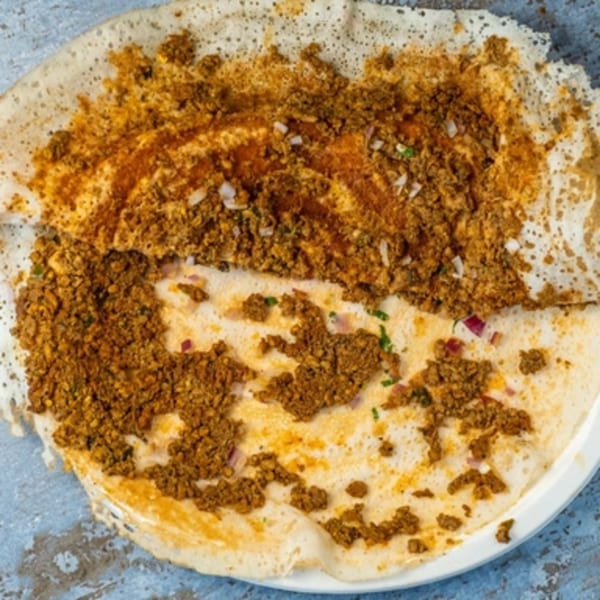 A Hello! India dosa, a thin Indian pancake, topped with a generous layer of spiced minced meat.